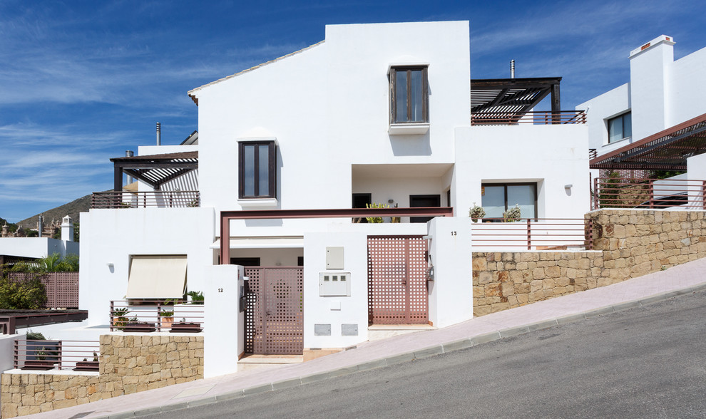 Стильный дизайн: белый дом среднего размера в средиземноморском стиле с разными уровнями, облицовкой из ЦСП и односкатной крышей - последний тренд