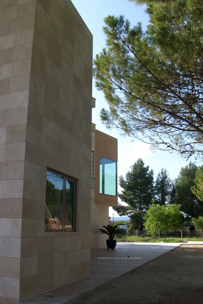Diseño de fachada beige moderna de dos plantas con revestimiento de piedra y tejado plano