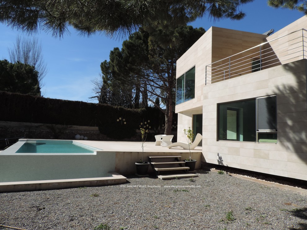 Diseño de fachada beige minimalista de dos plantas con revestimiento de piedra y tejado plano