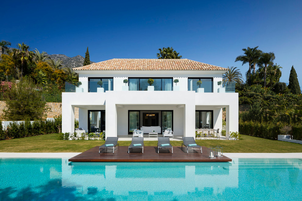 Стильный дизайн: двухэтажный, белый дом среднего размера в современном стиле с облицовкой из цементной штукатурки и вальмовой крышей - последний тренд