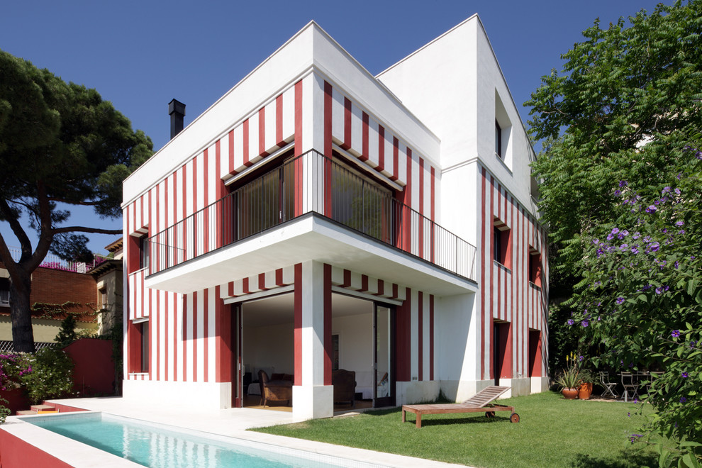 Ejemplo de fachada de casa multicolor ecléctica grande de tres plantas con revestimiento de estuco, tejado de un solo tendido y tejado de teja de barro