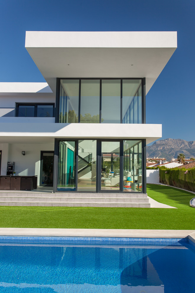 Идея дизайна: большой, двухэтажный, белый дом в стиле модернизм с комбинированной облицовкой и плоской крышей