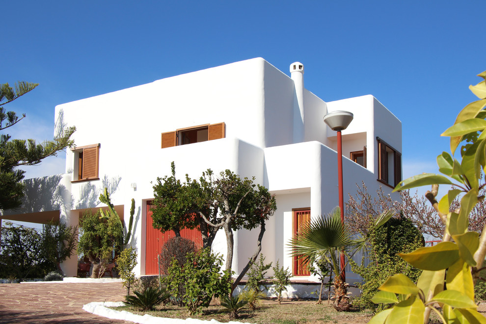 Réalisation d'une façade de maison blanche méditerranéenne à un étage avec un toit plat.