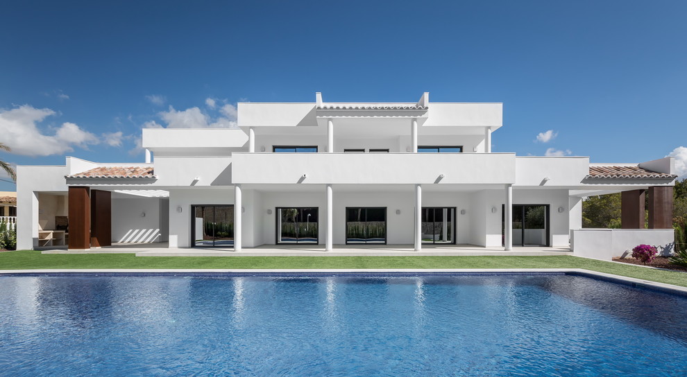 White and large mediterranean two floor render house exterior in Madrid with a flat roof.