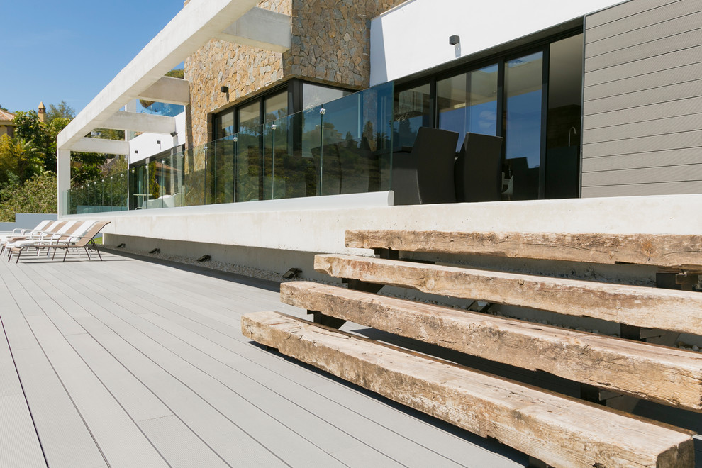 Diseño de fachada blanca mediterránea de tamaño medio de dos plantas con revestimiento de aglomerado de cemento y tejado plano