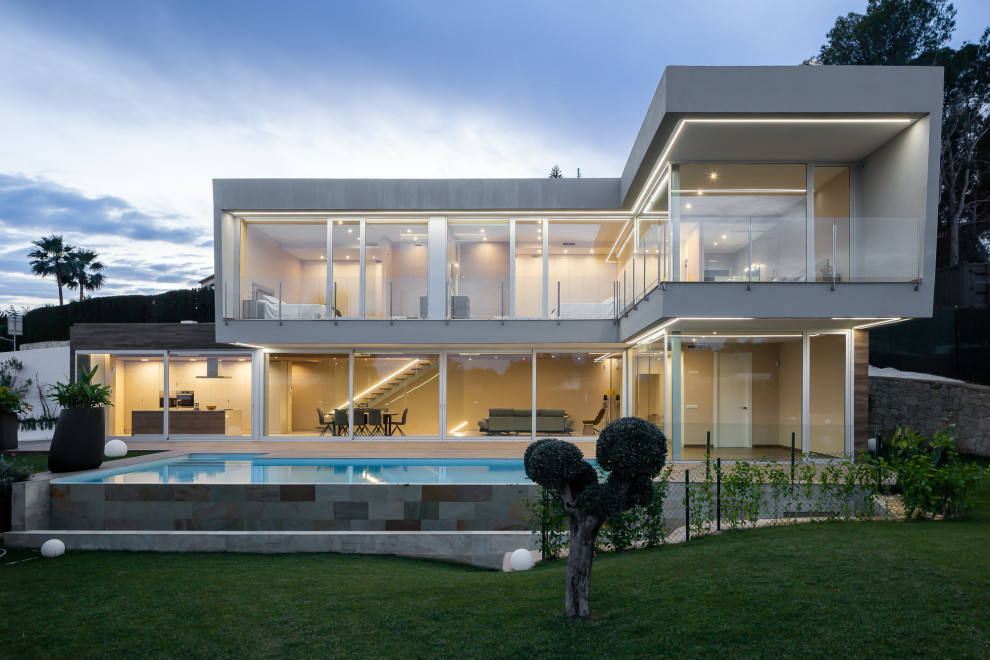 Modelo de fachada de casa gris contemporánea grande de dos plantas con revestimientos combinados y tejado plano
