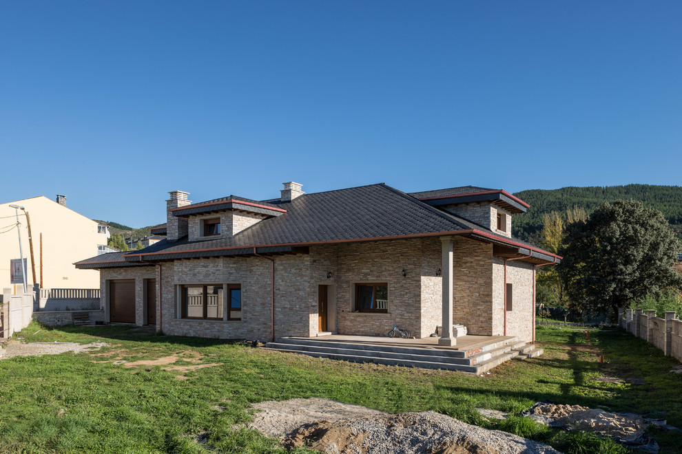 Idee per la villa rosa rustica di medie dimensioni con rivestimento in pietra e tetto a capanna