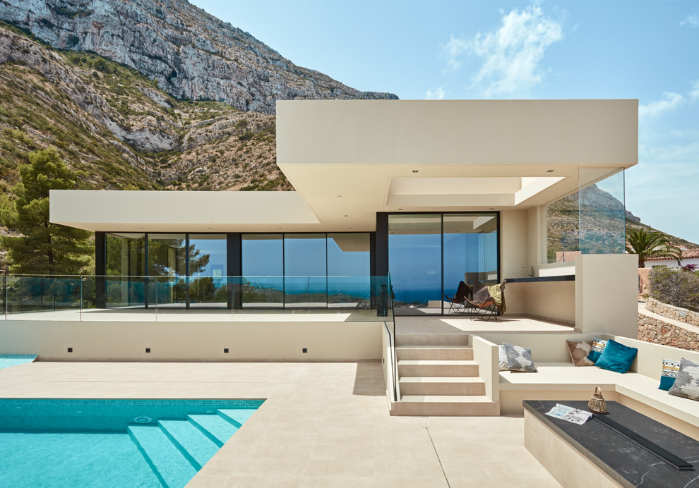 Inspiration pour une façade de maison beige minimaliste en verre de plain-pied avec un toit plat.