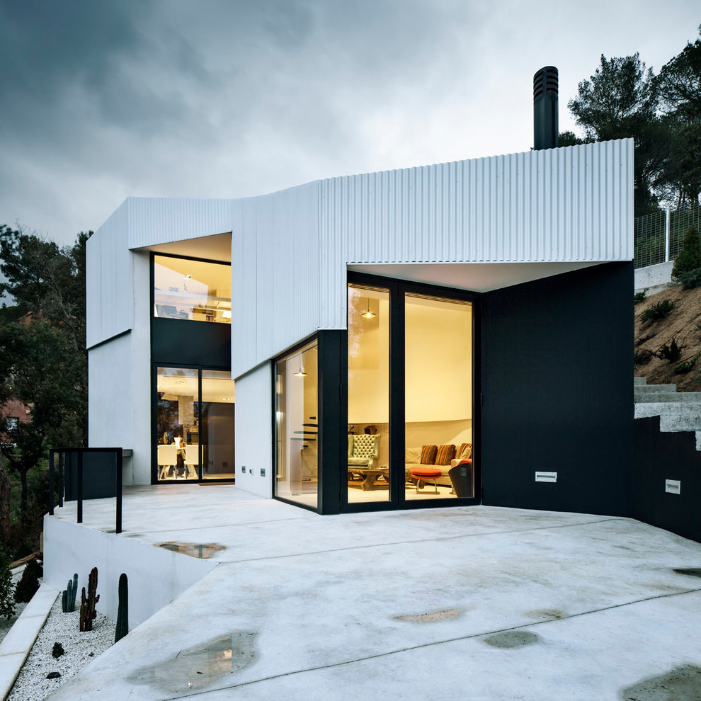 Стильный дизайн: большой, трехэтажный, белый дом в современном стиле с облицовкой из металла и плоской крышей - последний тренд