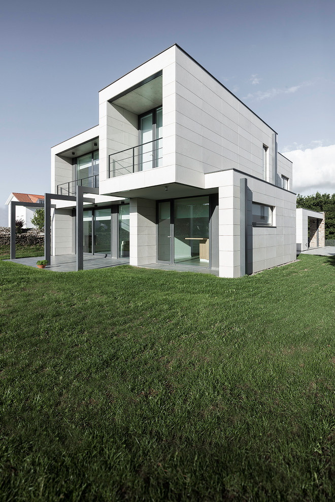 Réalisation d'une façade de maison design de taille moyenne et à un étage avec un toit plat.