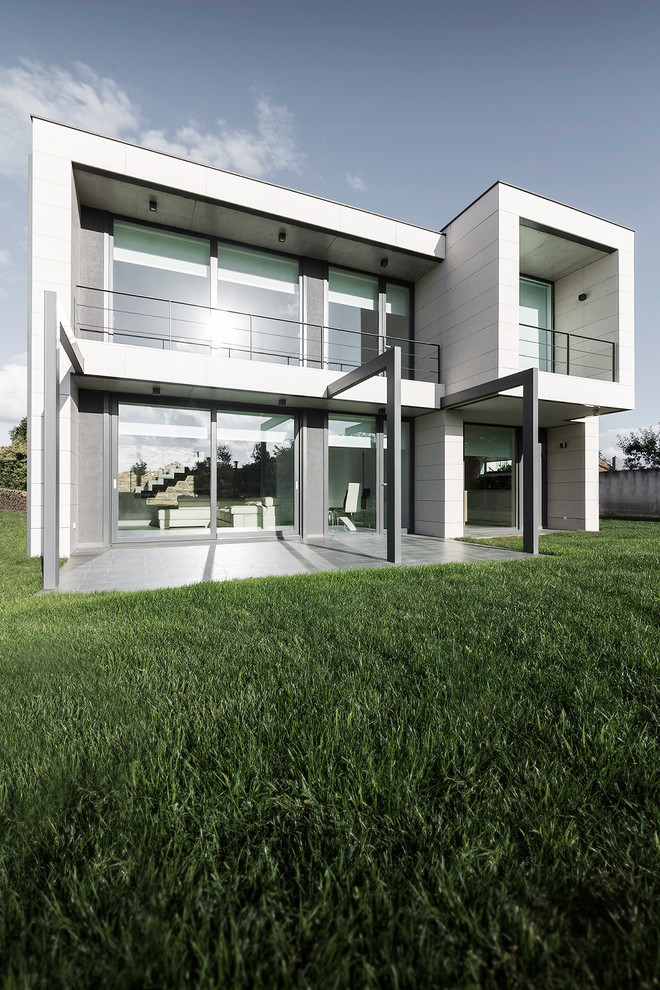 Foto della facciata di una casa grande bianca moderna a due piani con rivestimenti misti e tetto piano