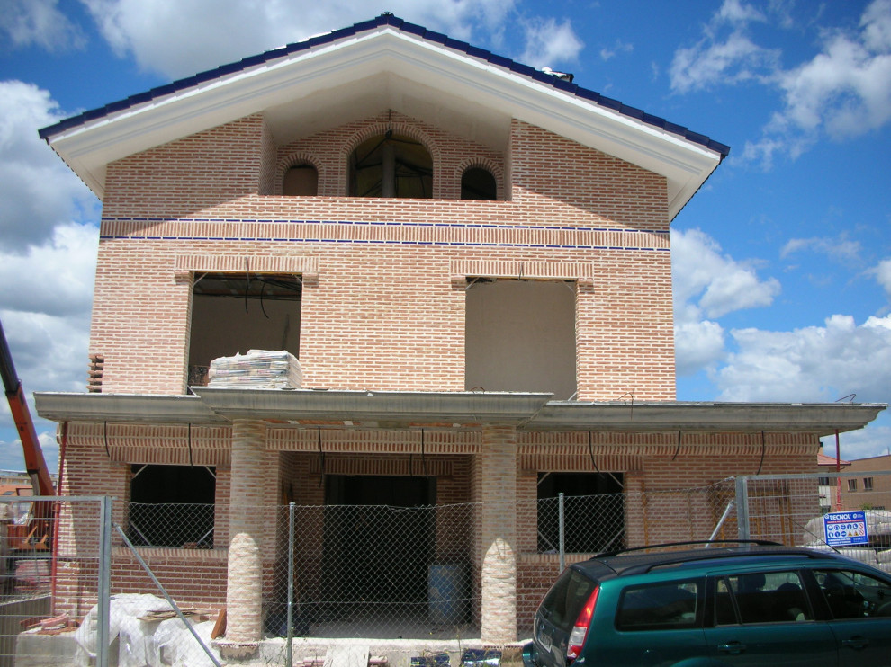 Geräumiges, Vierstöckiges Mediterranes Einfamilienhaus mit Backsteinfassade, roter Fassadenfarbe, Satteldach und Ziegeldach in Sonstige