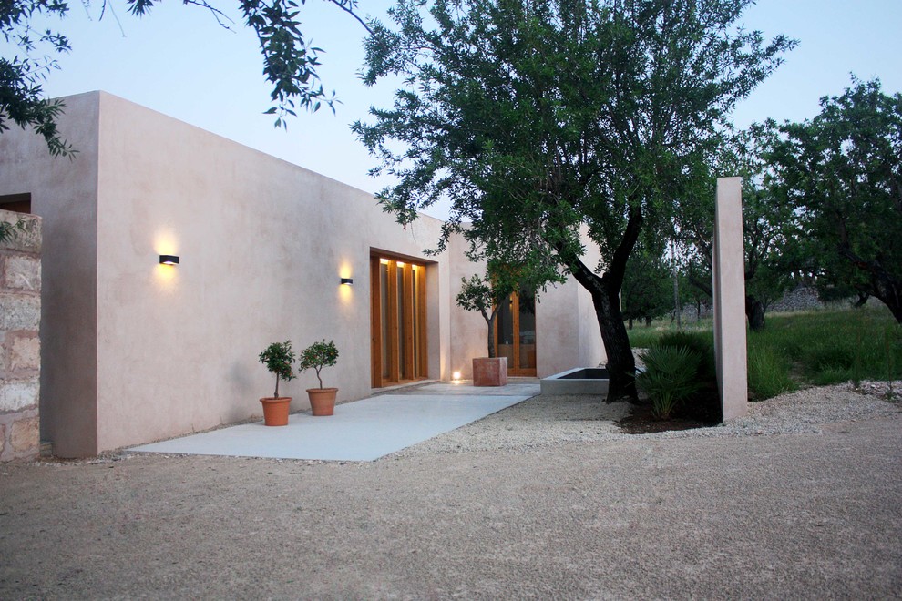 Idee per la facciata di una casa beige mediterranea a un piano di medie dimensioni con rivestimento con lastre in cemento e tetto piano