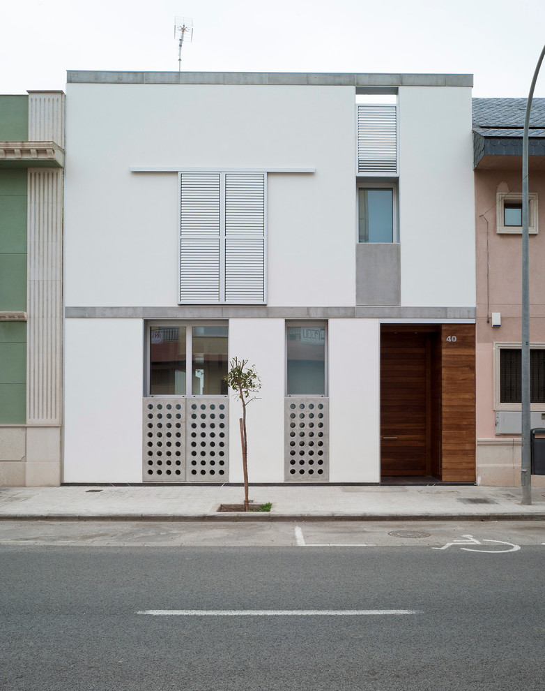 Modelo de fachada blanca contemporánea de tamaño medio de dos plantas con revestimiento de estuco y tejado plano