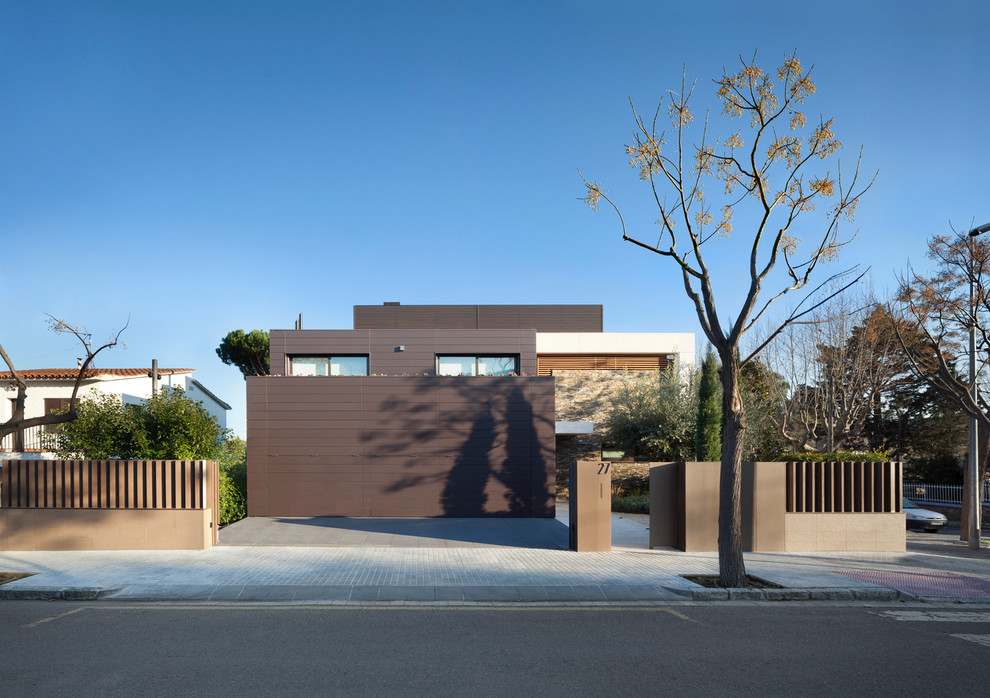 На фото: двухэтажный, коричневый дом среднего размера в современном стиле с комбинированной облицовкой и плоской крышей