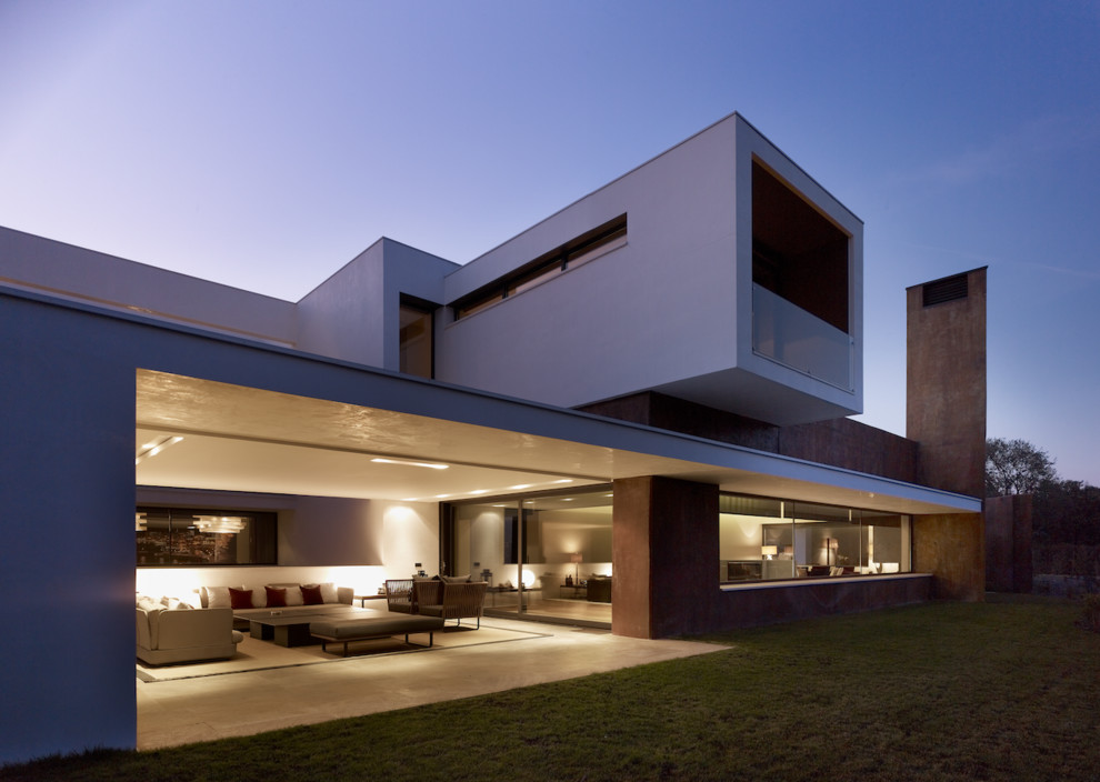Idée de décoration pour une grande façade de maison blanche minimaliste à un étage avec un revêtement mixte et un toit plat.