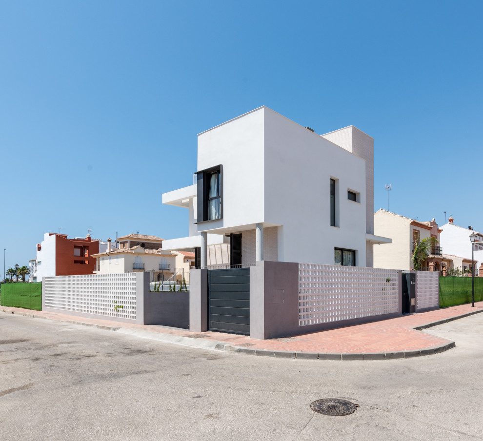 Mittelgroßes, Dreistöckiges Modernes Einfamilienhaus mit Mix-Fassade, weißer Fassadenfarbe, Flachdach und Misch-Dachdeckung in Madrid