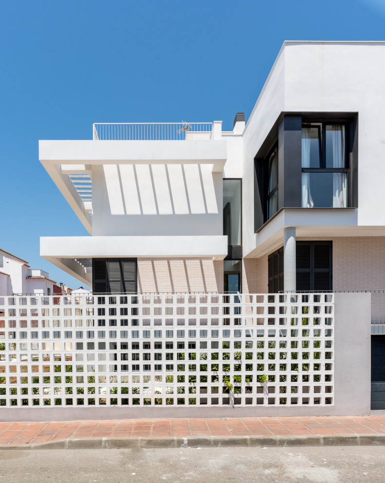 На фото: трехэтажный, белый частный загородный дом среднего размера в современном стиле с комбинированной облицовкой, плоской крышей и крышей из смешанных материалов с