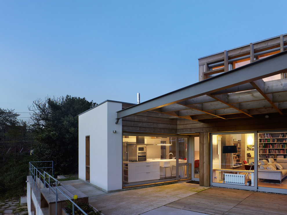 Diseño de fachada de casa actual grande de dos plantas con revestimientos combinados y tejado plano