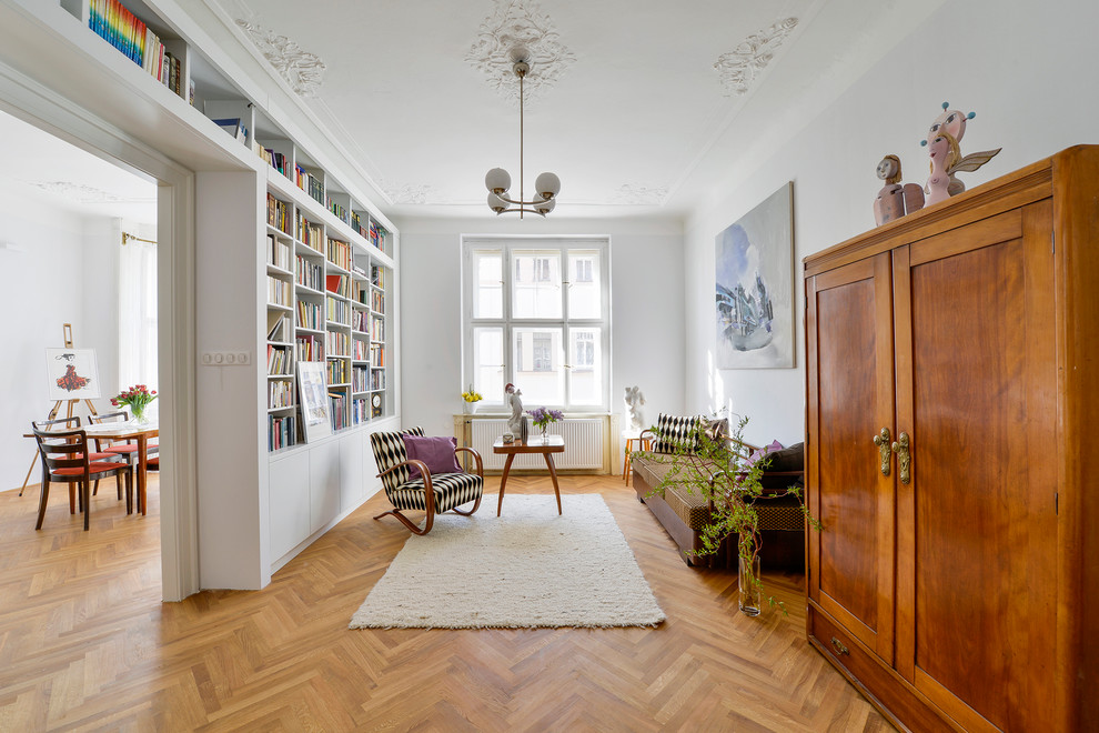 На фото: изолированная гостиная комната среднего размера в классическом стиле с серыми стенами, светлым паркетным полом и с книжными шкафами и полками без камина с