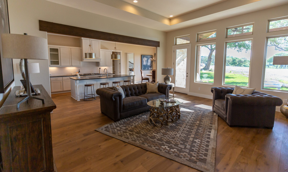 Diseño de sala de estar abierta campestre con paredes beige, suelo de madera en tonos medios y suelo marrón