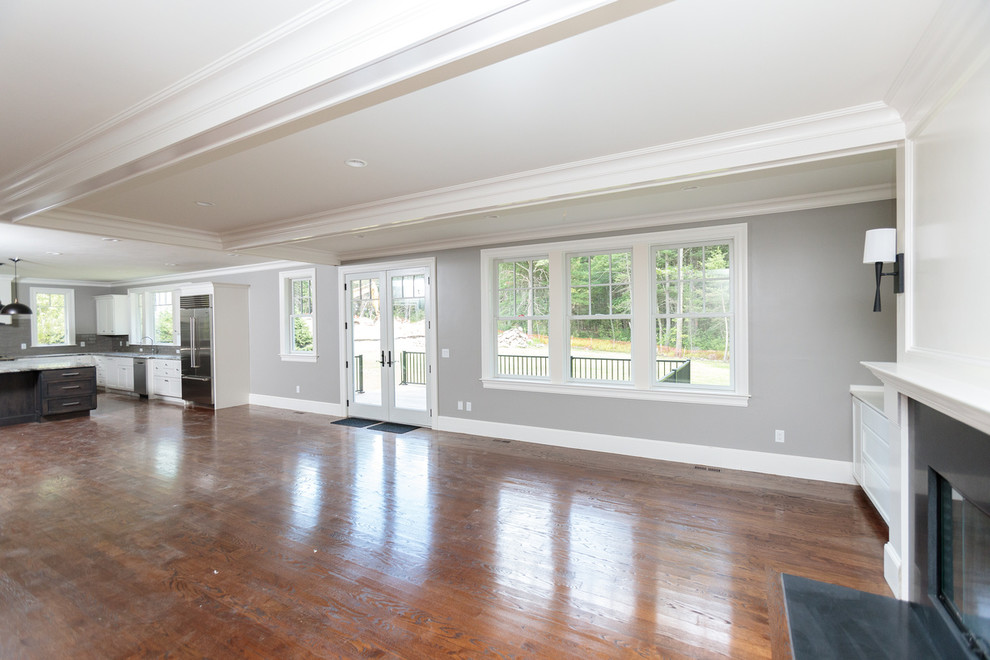 Example of a huge classic open concept dark wood floor family room design in Boston with gray walls, a standard fireplace and a wood fireplace surround