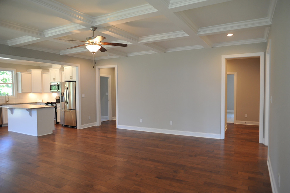 This is an example of a coastal open plan games room in Other with grey walls, medium hardwood flooring, a standard fireplace and a wooden fireplace surround.