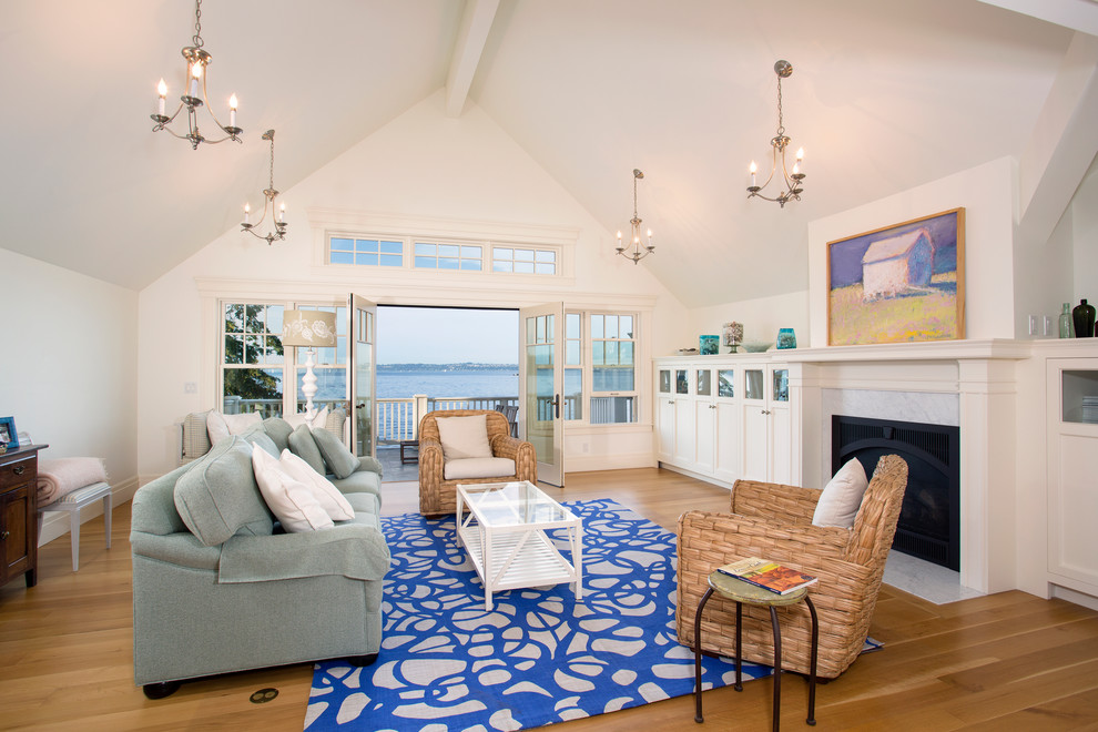 Großes Maritimes Wohnzimmer mit weißer Wandfarbe, braunem Holzboden, Kamin und Kaminumrandung aus Stein in Seattle
