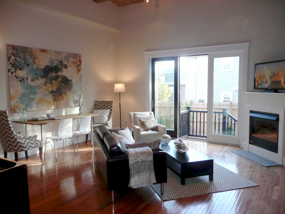 Cette photo montre une grande salle de séjour tendance ouverte avec un mur gris, parquet clair, une cheminée d'angle, un téléviseur indépendant, un manteau de cheminée en plâtre et un sol marron.