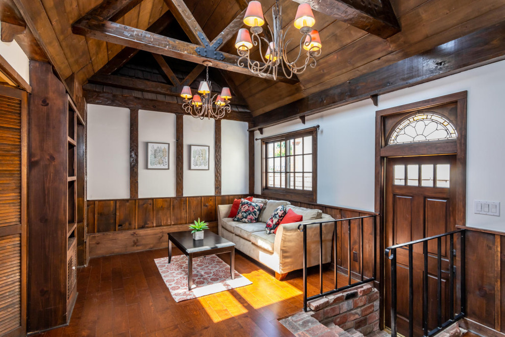 Esempio di un soggiorno aperto con pareti bianche, pavimento in legno massello medio e pavimento marrone