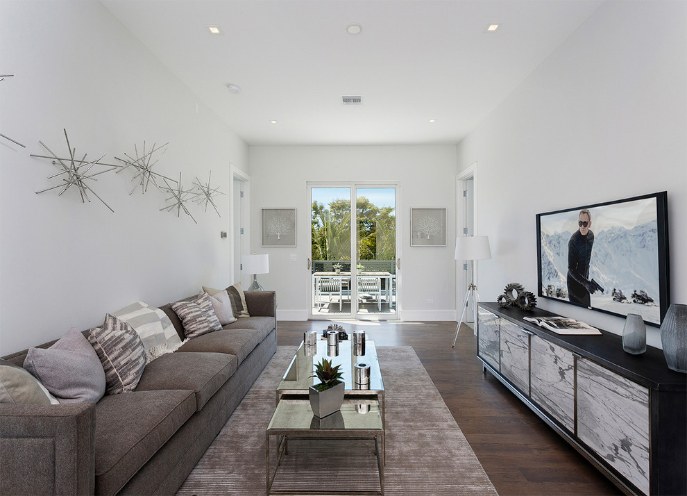 Foto di un soggiorno minimalista di medie dimensioni e stile loft con pareti bianche, parquet scuro, nessun camino, TV a parete, pavimento marrone e tappeto