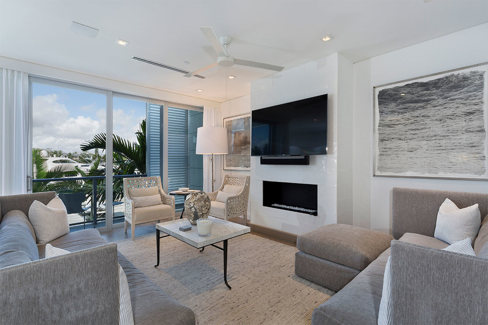 Mittelgroßes Modernes Wohnzimmer im Loft-Stil mit weißer Wandfarbe, braunem Holzboden, Gaskamin, Kaminumrandung aus Beton, TV-Wand und braunem Boden in Miami