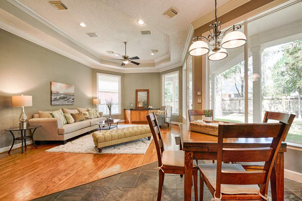 Imagen de sala de estar abierta clásica renovada de tamaño medio sin chimenea y televisor con paredes verdes, suelo de madera en tonos medios y suelo marrón