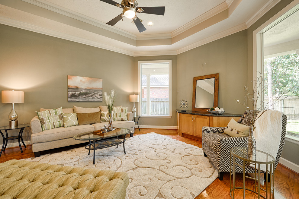Diseño de sala de estar abierta clásica renovada de tamaño medio sin chimenea y televisor con paredes verdes, suelo de madera en tonos medios y suelo marrón