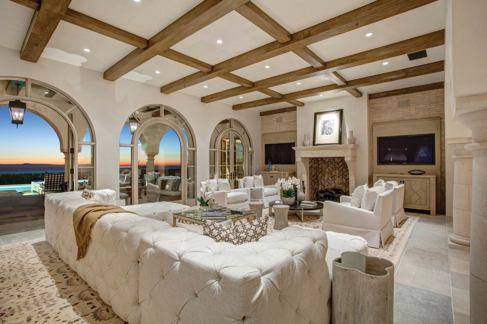 Источник вдохновения для домашнего уюта: гостиная комната в средиземноморском стиле с белыми стенами, стандартным камином и телевизором на стене