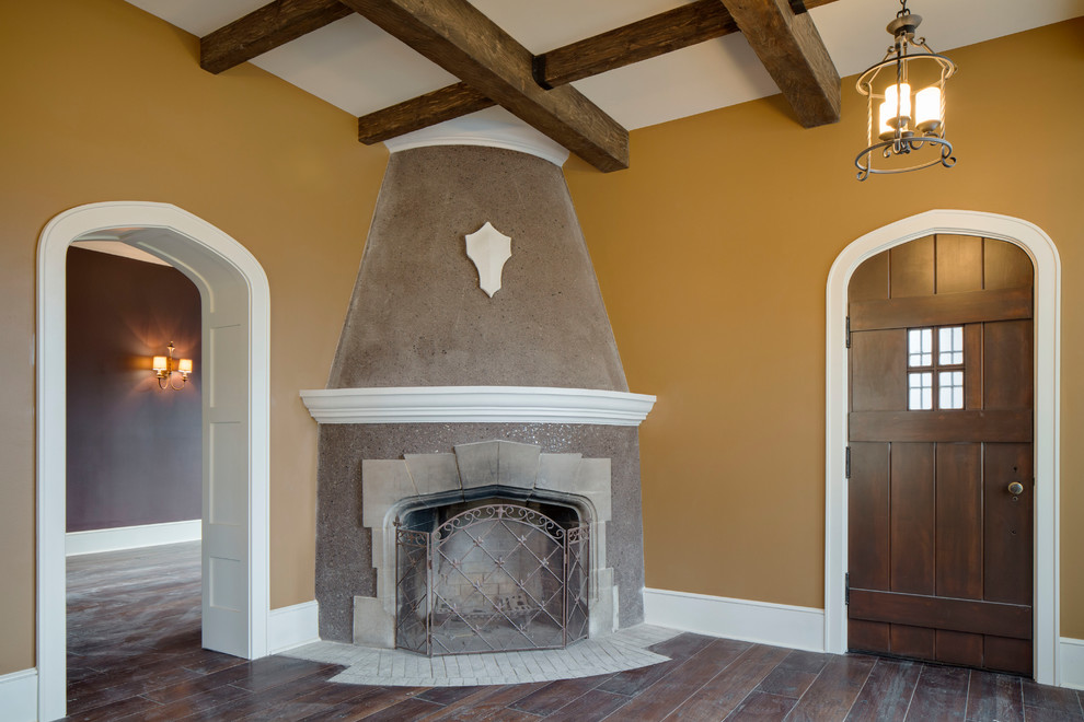 Aménagement d'une salle de séjour classique avec parquet foncé, un manteau de cheminée en pierre, un sol marron et un mur jaune.