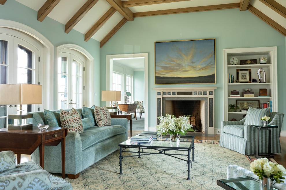 Abgetrenntes Klassisches Wohnzimmer mit blauer Wandfarbe, braunem Holzboden, Kamin, braunem Boden, freigelegten Dachbalken und gewölbter Decke in Sonstige