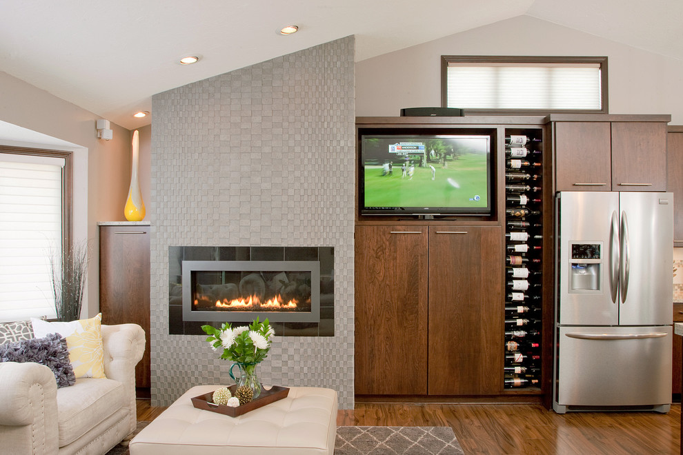 Inspiration for a medium sized contemporary open plan games room in Minneapolis with beige walls, medium hardwood flooring, a ribbon fireplace, a freestanding tv, a tiled fireplace surround and brown floors.
