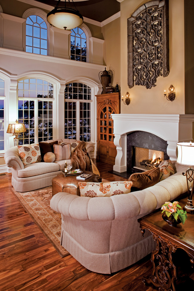 Expansive mediterranean open plan games room in Indianapolis with beige walls, medium hardwood flooring, a standard fireplace, a wooden fireplace surround and no tv.