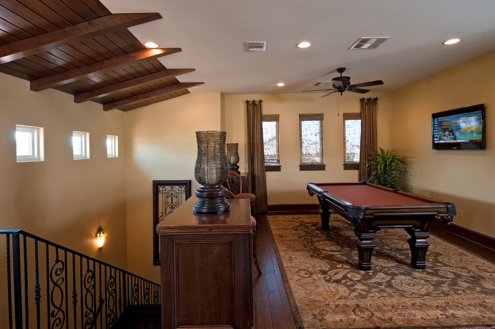Huge tuscan open concept dark wood floor game room photo in Austin with beige walls and a wall-mounted tv