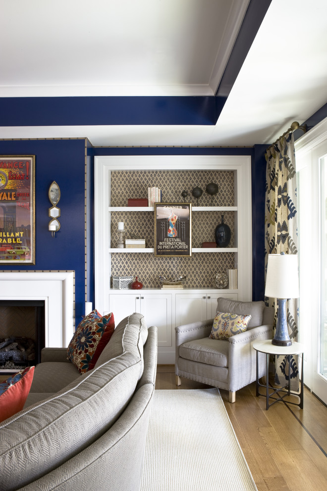 Bohemian games room in DC Metro with blue walls, light hardwood flooring and a standard fireplace.