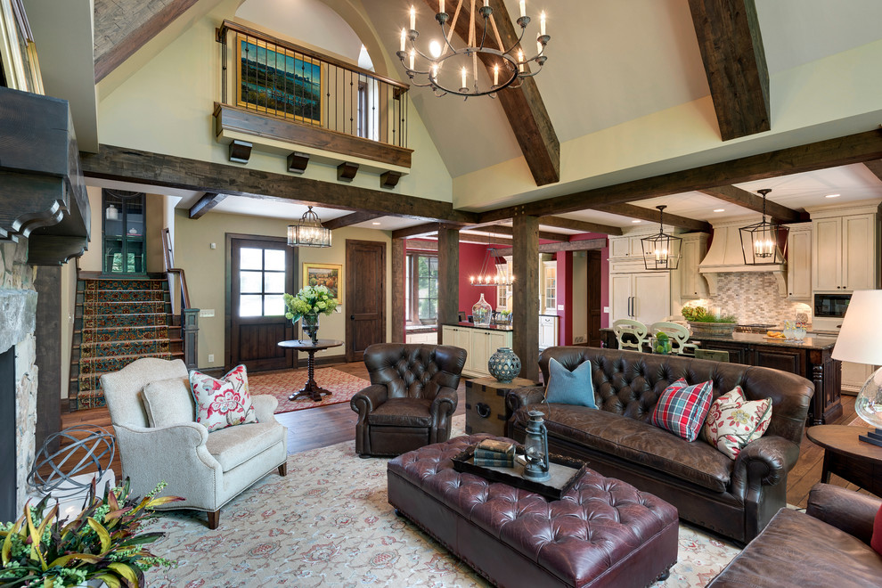 Example of a huge mountain style open concept medium tone wood floor family room design in Minneapolis with beige walls, a two-sided fireplace, a stone fireplace and a wall-mounted tv
