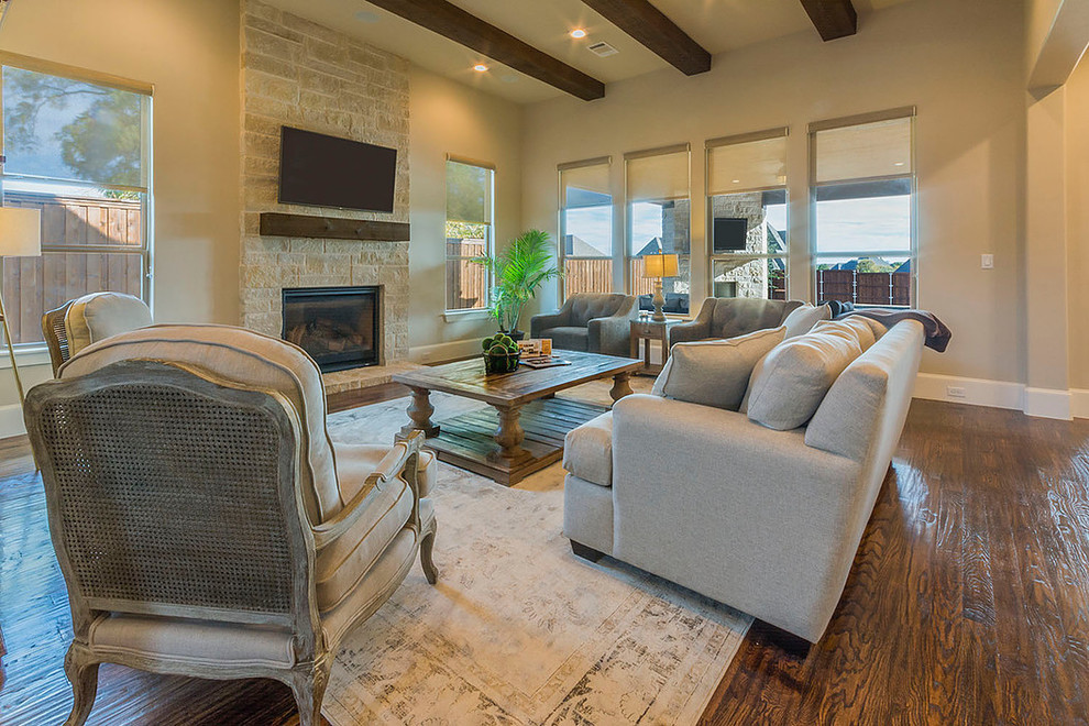 Photo of a medium sized classic open plan games room in Dallas with beige walls, medium hardwood flooring, a standard fireplace, a stone fireplace surround and a wall mounted tv.