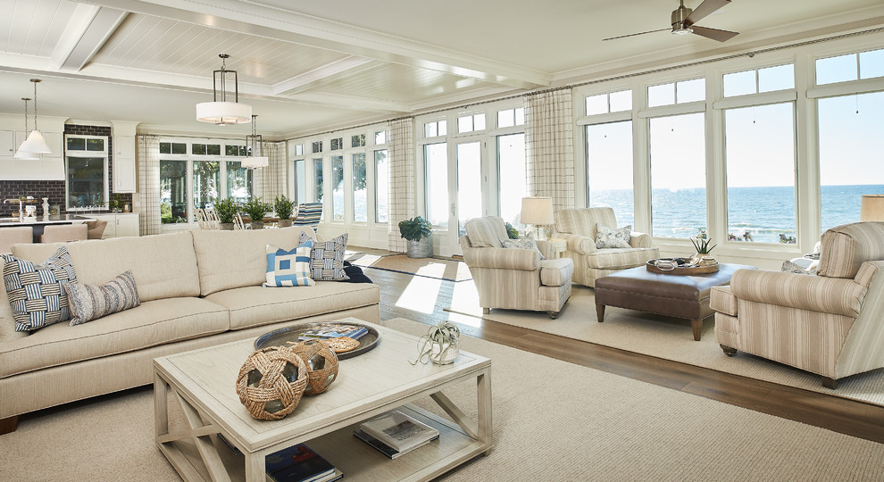 Idee per un grande soggiorno stile marinaro aperto con pavimento in legno massello medio, pareti bianche e tappeto