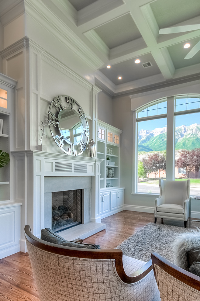 This is an example of a large classic open plan games room in Salt Lake City with grey walls, medium hardwood flooring, no tv, a standard fireplace and a stone fireplace surround.