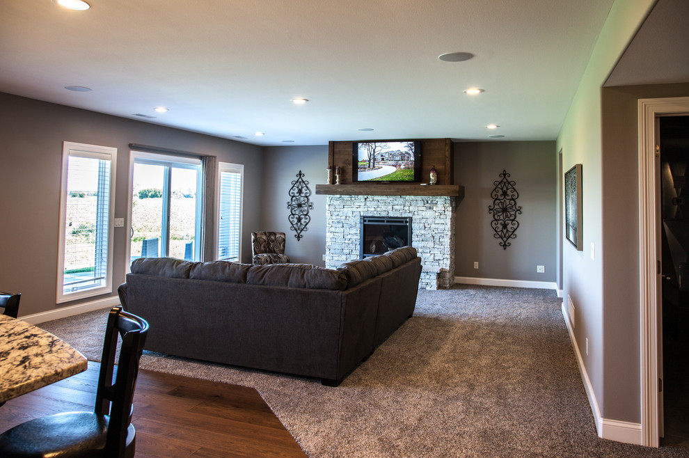 Klassisches Wohnzimmer mit beiger Wandfarbe, dunklem Holzboden, Kamin, Kaminumrandung aus Stein, TV-Wand und braunem Boden in Sonstige