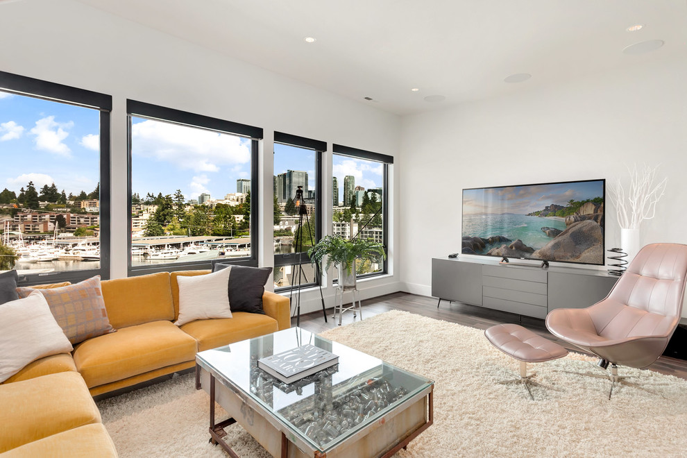 Mittelgroßes, Abgetrenntes Modernes Wohnzimmer mit grauer Wandfarbe, braunem Holzboden, freistehendem TV und braunem Boden in Seattle