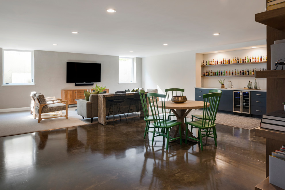 Photo of a large traditional open plan games room in Minneapolis with a home bar, white walls, concrete flooring, a wall mounted tv and brown floors.