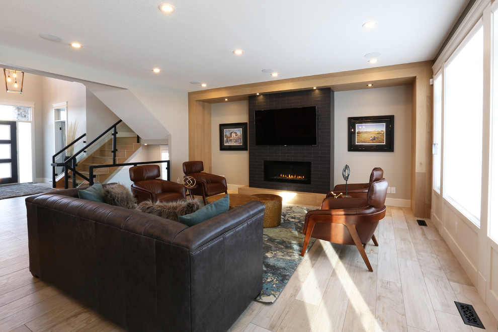 Свежая идея для дизайна: гостиная комната в стиле модернизм с серыми стенами, полом из керамической плитки, стандартным камином, фасадом камина из плитки, телевизором на стене и бежевым полом - отличное фото интерьера