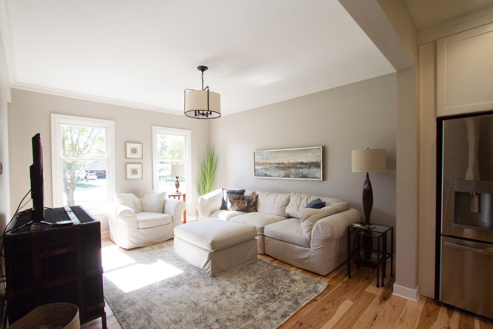 Abgetrenntes Klassisches Wohnzimmer mit beiger Wandfarbe, hellem Holzboden und freistehendem TV in Sonstige